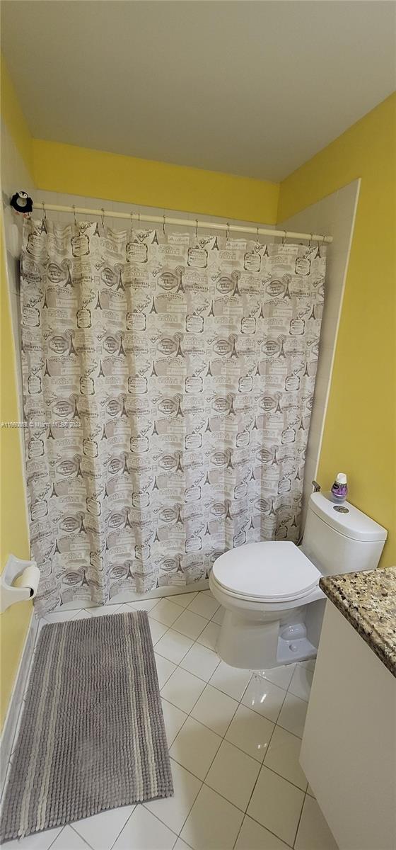 full bathroom featuring shower / bath combo, vanity, toilet, and tile patterned floors