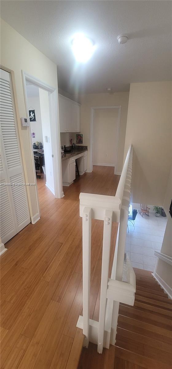 stairway with baseboards and wood finished floors