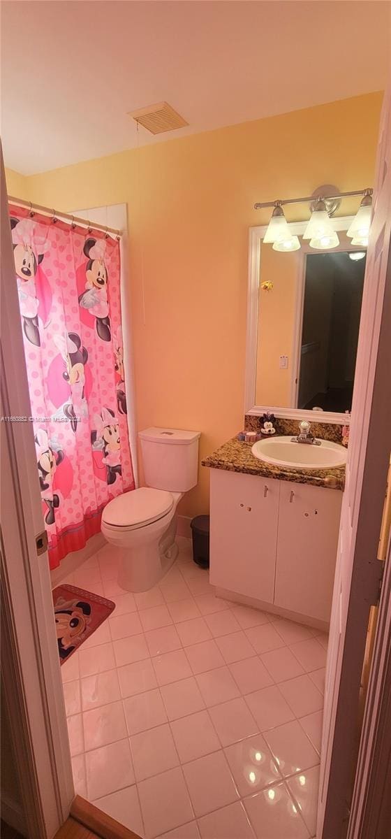 bathroom with tile patterned flooring, vanity, toilet, and a shower with shower curtain