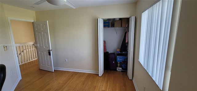 unfurnished bedroom with ceiling fan, light hardwood / wood-style flooring, and a closet