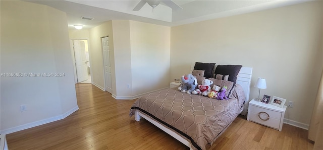 bedroom with ceiling fan, light hardwood / wood-style flooring, and a closet