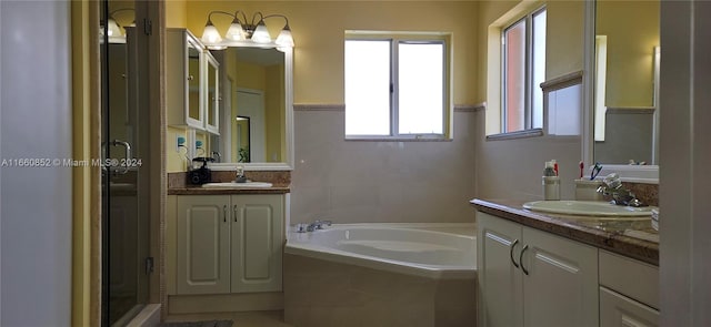 bathroom featuring tiled bath and vanity