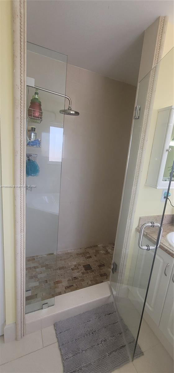 bathroom with vanity, an enclosed shower, and tile patterned floors