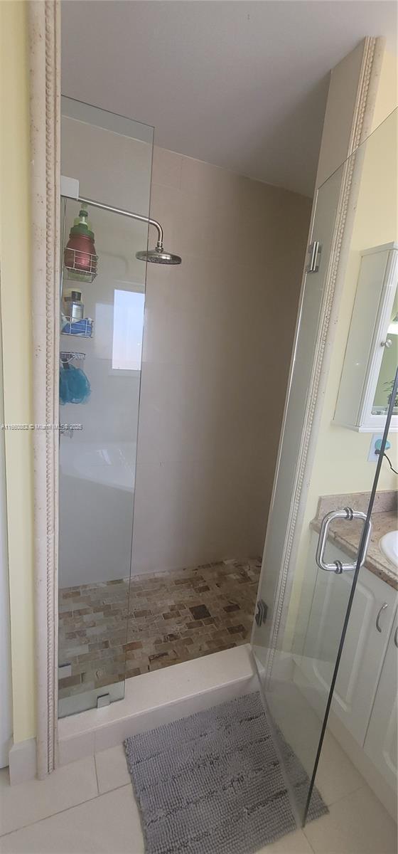 bathroom with tile patterned floors, a stall shower, and vanity