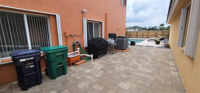 view of patio / terrace featuring a fenced in pool and a grill