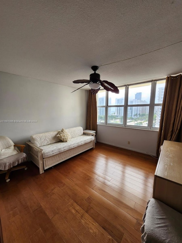 unfurnished bedroom featuring ceiling fan, hardwood / wood-style flooring, and a textured ceiling