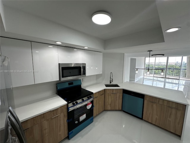 kitchen with white cabinetry, appliances with stainless steel finishes, decorative light fixtures, and sink