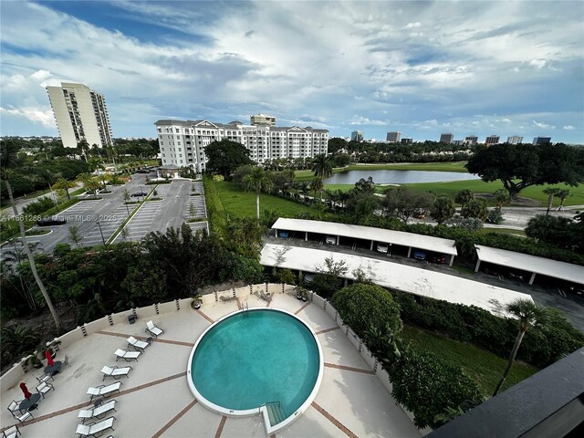 view of pool with a water view and a patio area