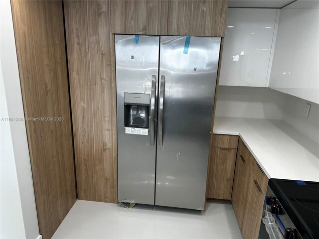 kitchen featuring stainless steel refrigerator with ice dispenser and stove