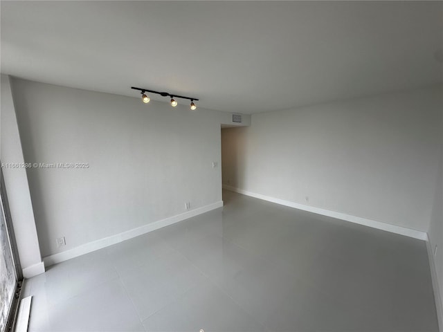 unfurnished room featuring rail lighting