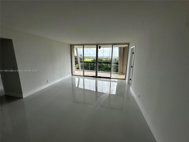 unfurnished room with concrete floors and floor to ceiling windows