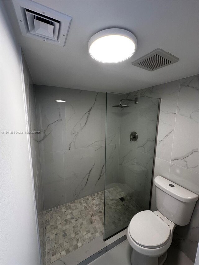 bathroom featuring toilet and tiled shower