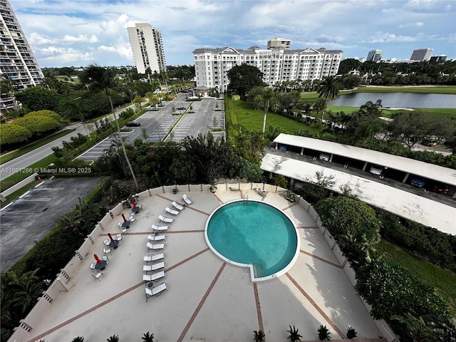 view of pool featuring a water view and a patio