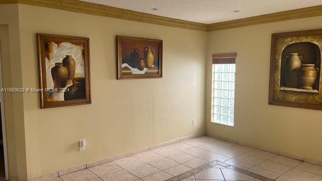 tiled spare room featuring a textured ceiling and crown molding