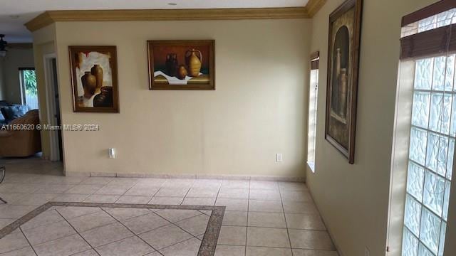 tiled spare room featuring crown molding