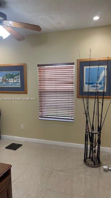 interior space featuring ceiling fan and a textured ceiling