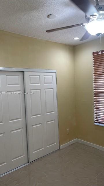 unfurnished bedroom featuring a closet, ceiling fan, and a textured ceiling