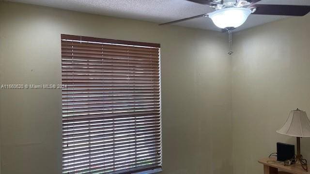 interior details with a ceiling fan and a textured ceiling