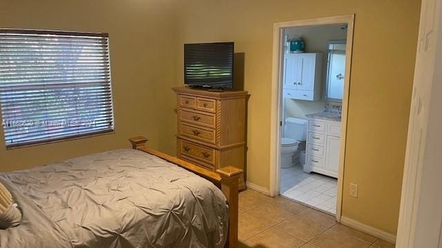 tiled bedroom featuring connected bathroom