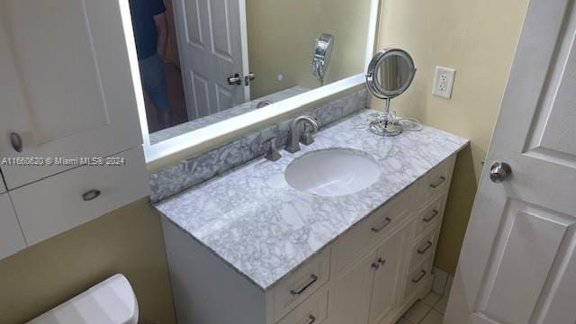 bathroom featuring toilet, tile patterned flooring, and vanity