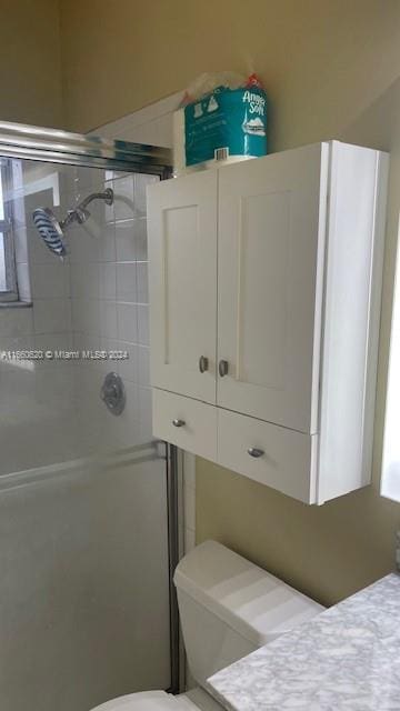 bathroom with vanity, a shower stall, and toilet