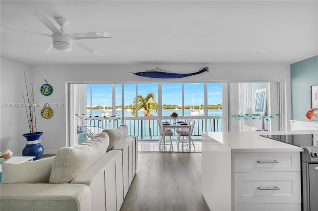 living room featuring a water view, ceiling fan, and hardwood / wood-style flooring