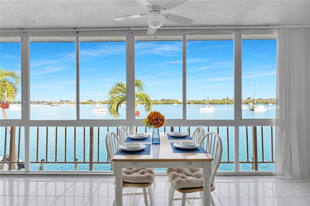 sunroom / solarium with a water view and ceiling fan