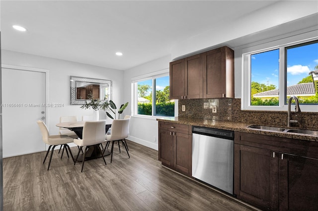 kitchen with dark stone counters, dishwasher, dark hardwood / wood-style floors, sink, and decorative backsplash