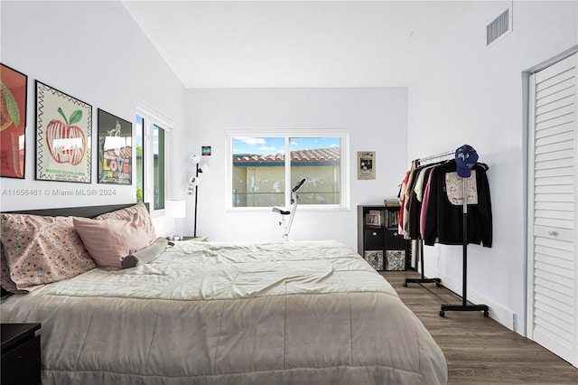 bedroom with vaulted ceiling and hardwood / wood-style flooring