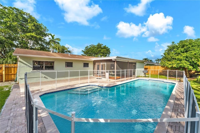 view of swimming pool featuring a patio and a sunroom