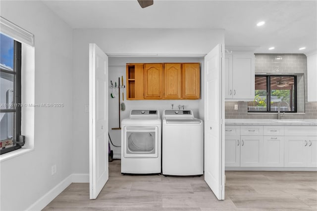 laundry area with cabinets, washer and dryer, sink, and ceiling fan