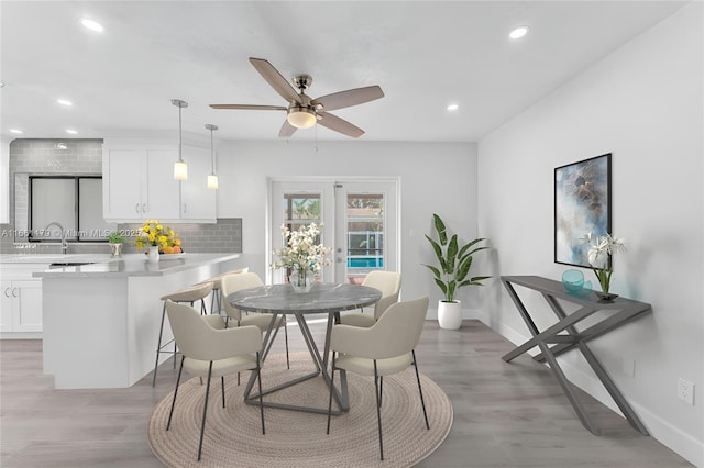 dining area with light hardwood / wood-style floors, french doors, and ceiling fan