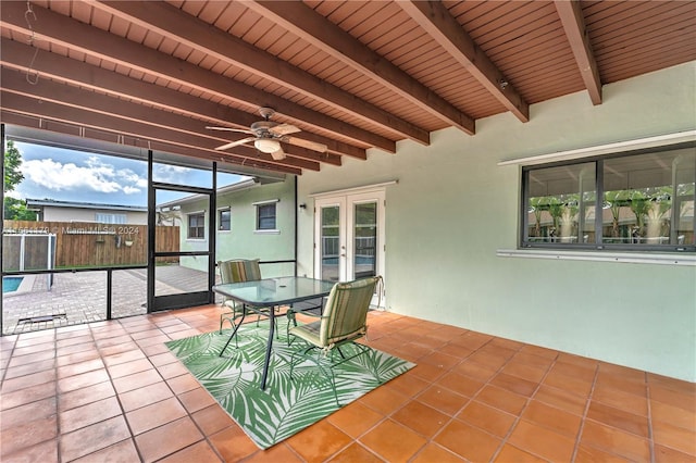 unfurnished sunroom with wooden ceiling, beamed ceiling, and ceiling fan