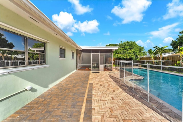 view of swimming pool with a patio and a sunroom