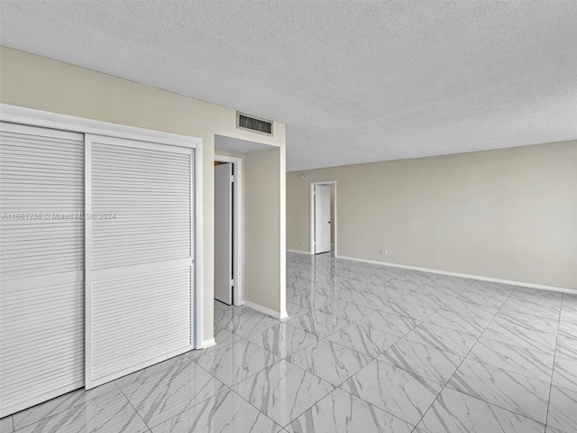 unfurnished bedroom featuring a closet and a textured ceiling