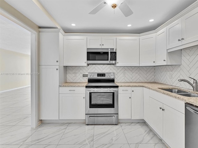 kitchen featuring ceiling fan, appliances with stainless steel finishes, tasteful backsplash, and white cabinetry