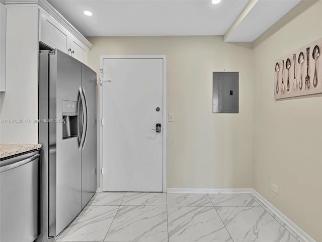 kitchen with white cabinets, electric panel, light stone countertops, and stainless steel fridge