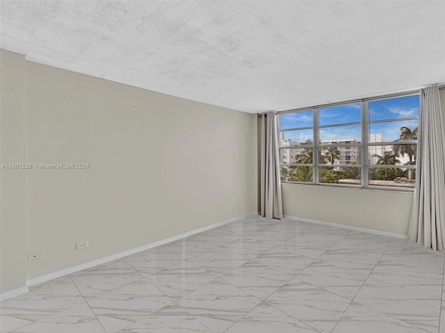 unfurnished room featuring a textured ceiling