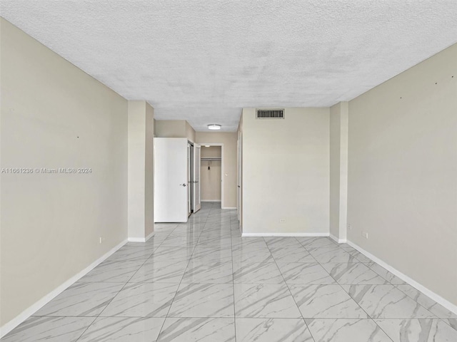 unfurnished room featuring a textured ceiling