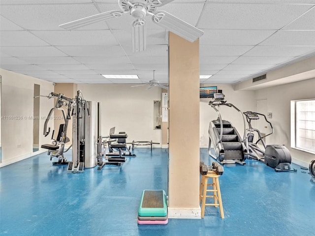 workout area featuring a drop ceiling, concrete flooring, and ceiling fan