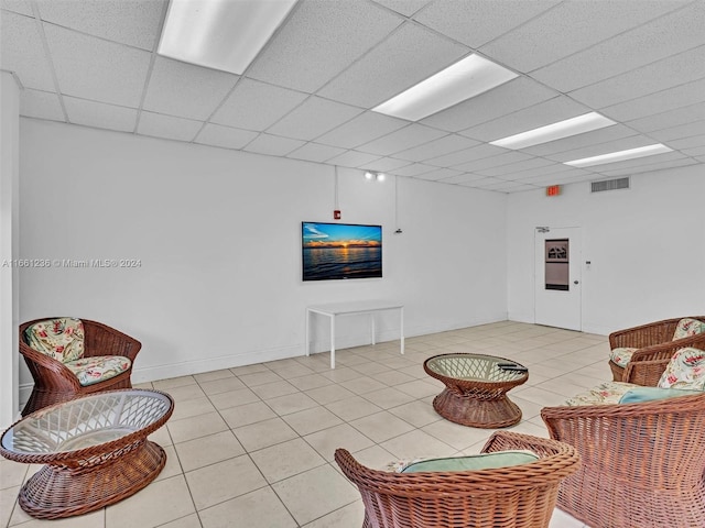 tiled living room featuring a paneled ceiling