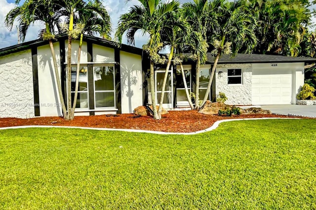 view of front of home with a front yard and a garage