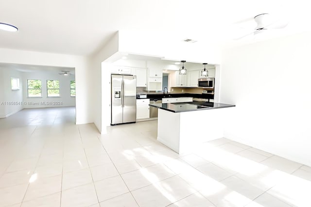 kitchen featuring ceiling fan, light tile patterned flooring, hanging light fixtures, white cabinetry, and stainless steel appliances