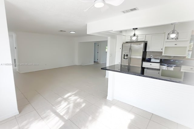 kitchen with ceiling fan, stainless steel fridge, light tile patterned floors, decorative light fixtures, and white cabinetry