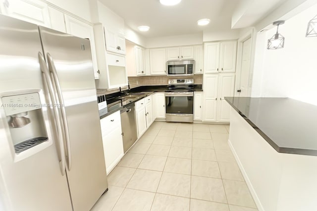 kitchen with pendant lighting, light tile patterned floors, sink, white cabinetry, and appliances with stainless steel finishes