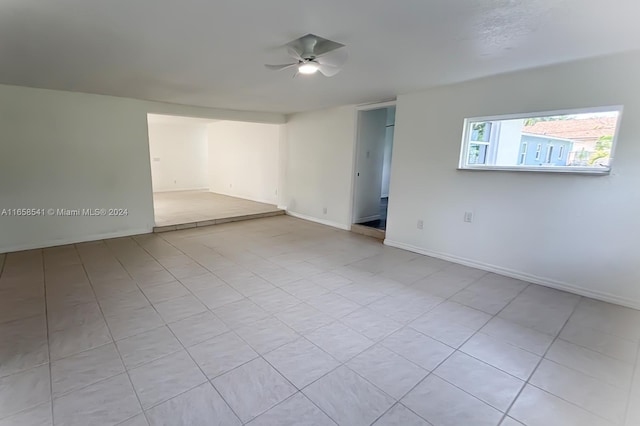 unfurnished room with light tile patterned floors and ceiling fan