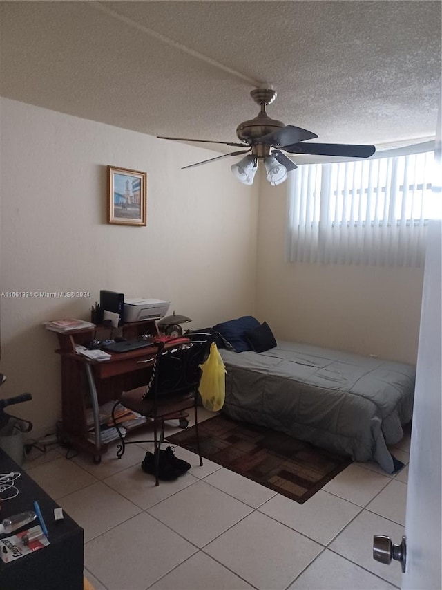 bedroom with a textured ceiling, tile patterned flooring, and ceiling fan