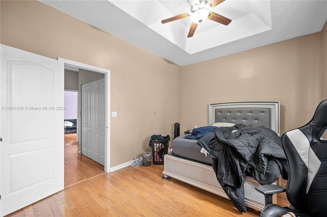 bedroom featuring a textured ceiling, light hardwood / wood-style flooring, and ceiling fan