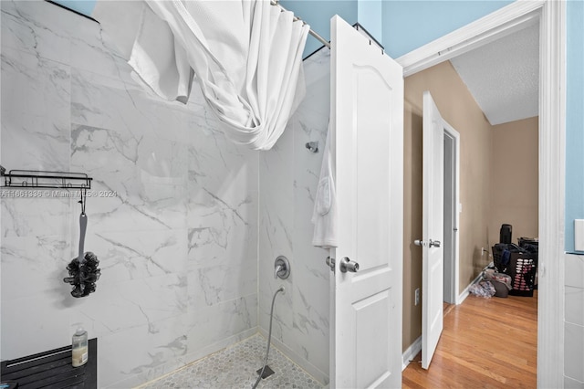 bathroom featuring curtained shower, wood-type flooring, and a textured ceiling