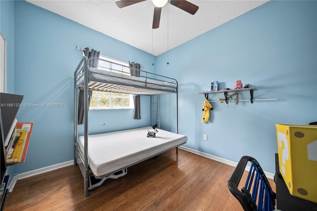 bedroom with a textured ceiling, hardwood / wood-style flooring, and ceiling fan